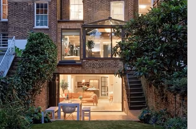 Glazed rear extension on a London terraced house at dusk