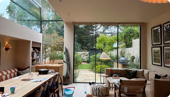 a living room with floor to ceiling windows overlooking the garden