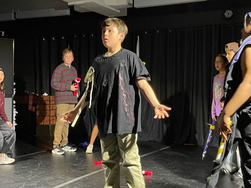 Drama club students on stage during a performance