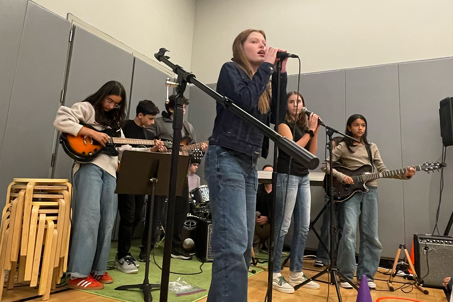 Middle school band performs with microphones and instruments