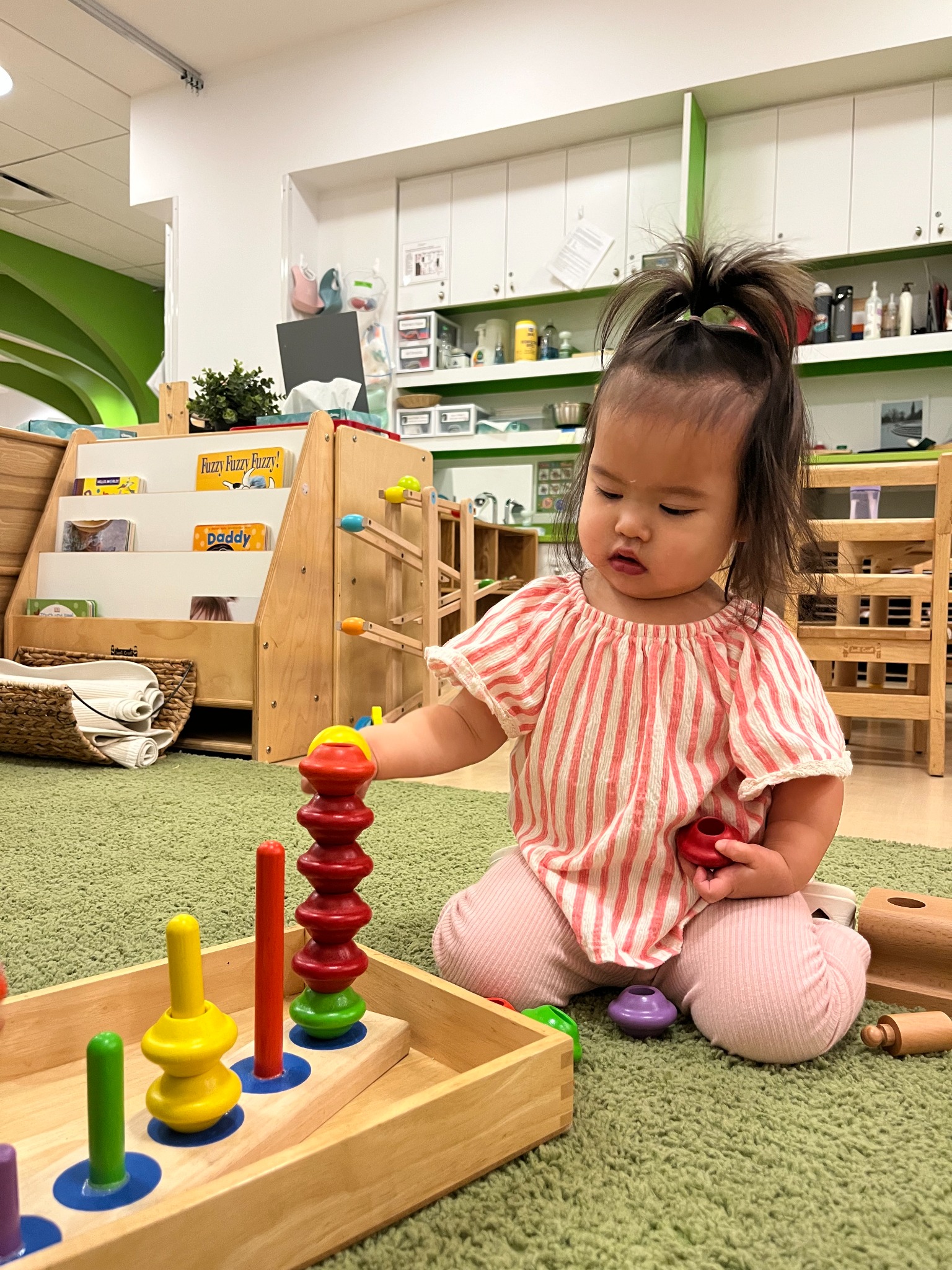 Nursery student playing with wooden tools during early care