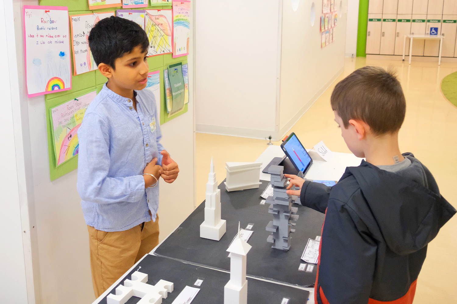 Student presenting 3d printed models of building to his classmate