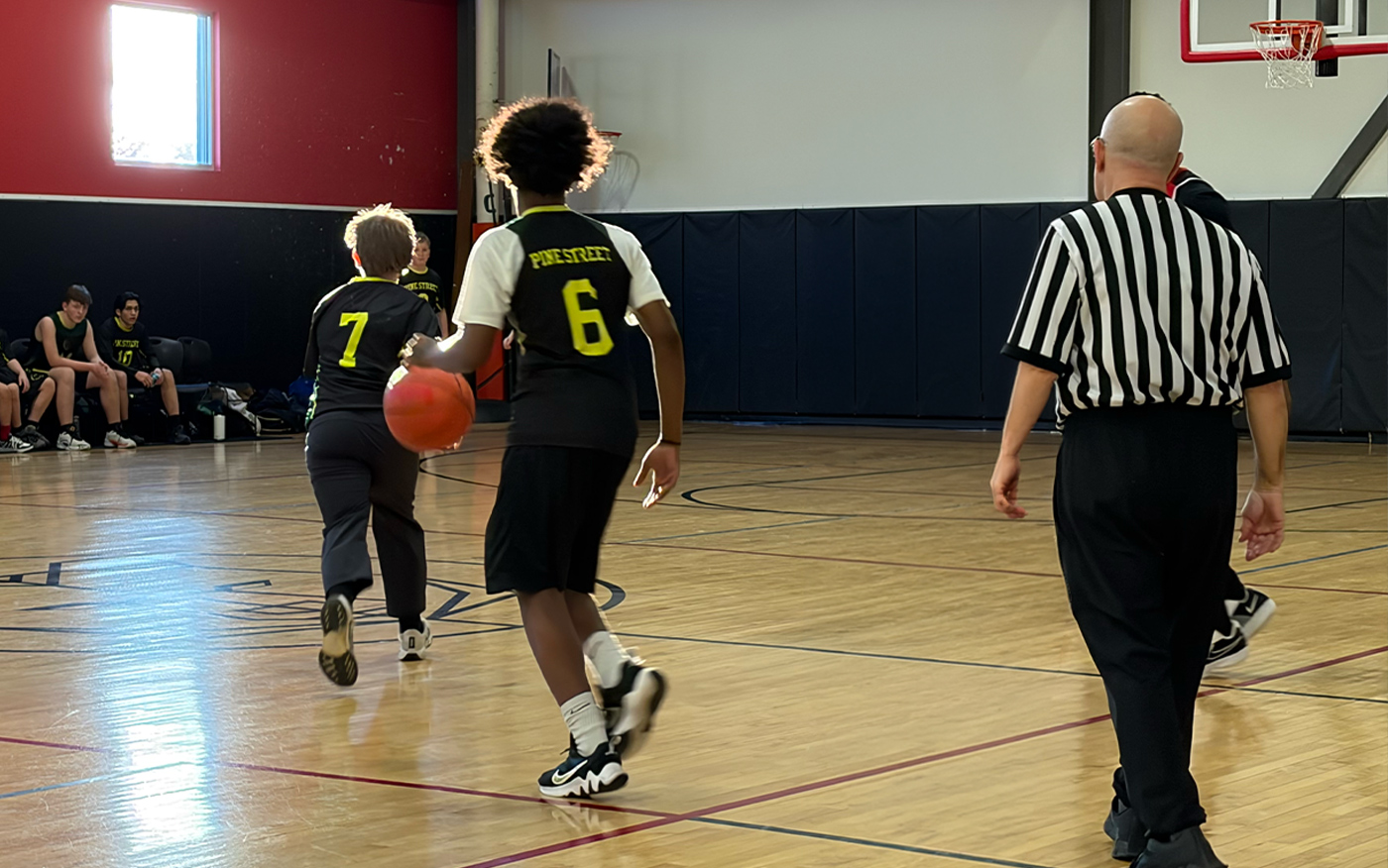 Pine Street School basketball team plays in a game against another school