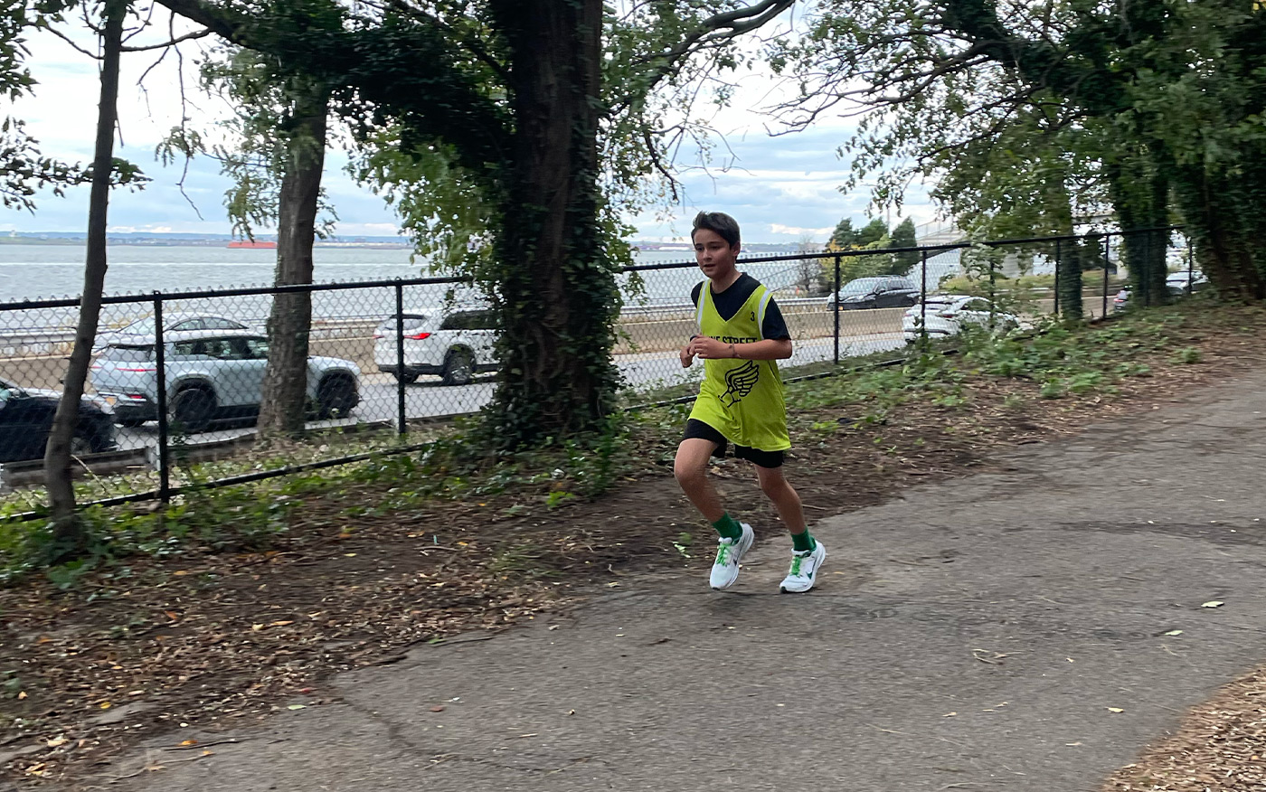 Cross country team member runs outside during a meet