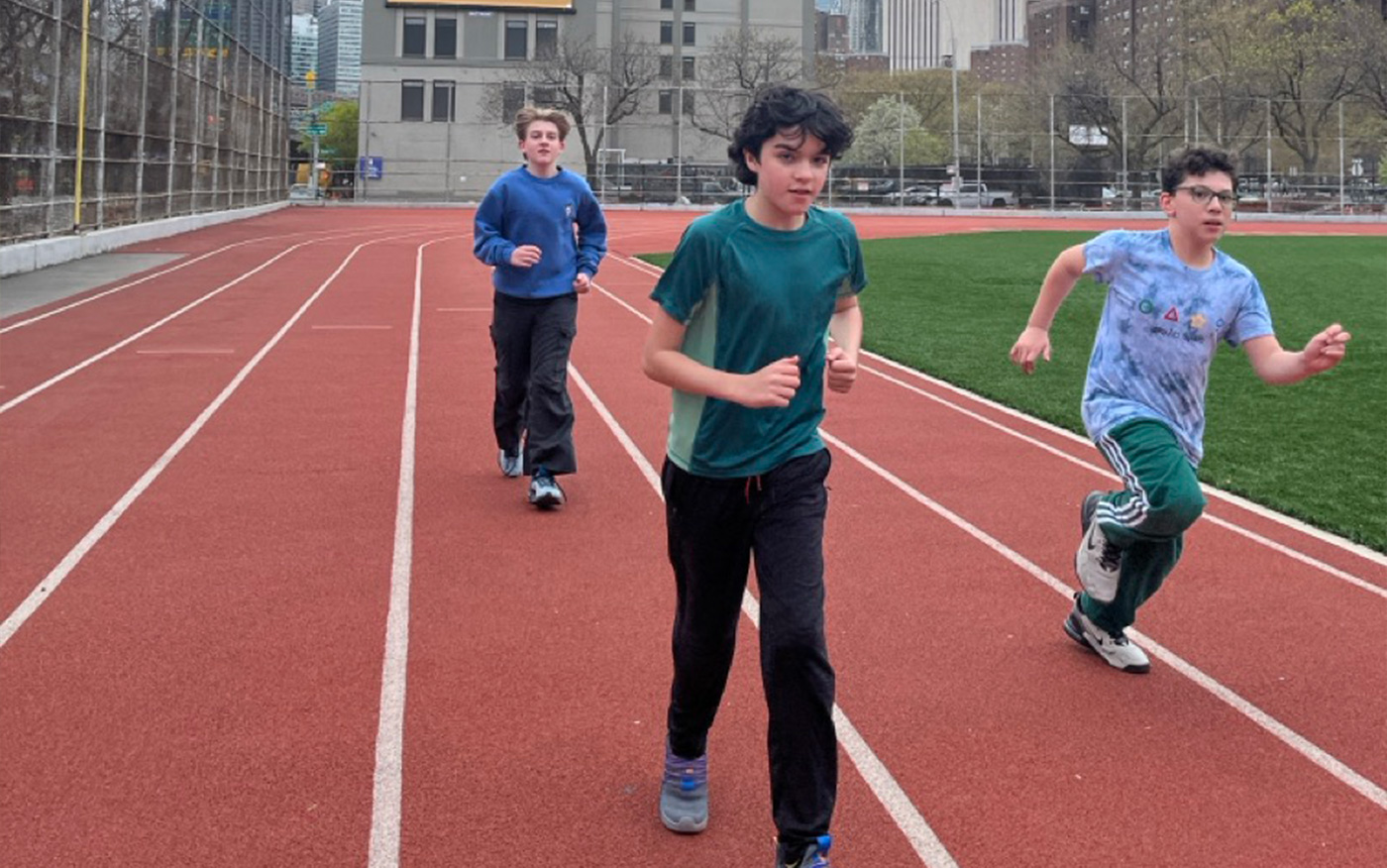 Track & Field team members run during practice at a track