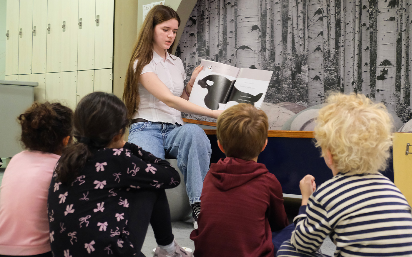 8th grader reads to Kindergarten class as part of the mentorship buddy program