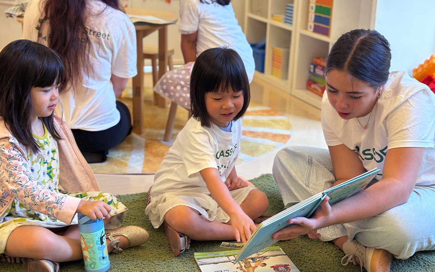 8th grader reads to Kindergarten students as part of the mentorship buddy program