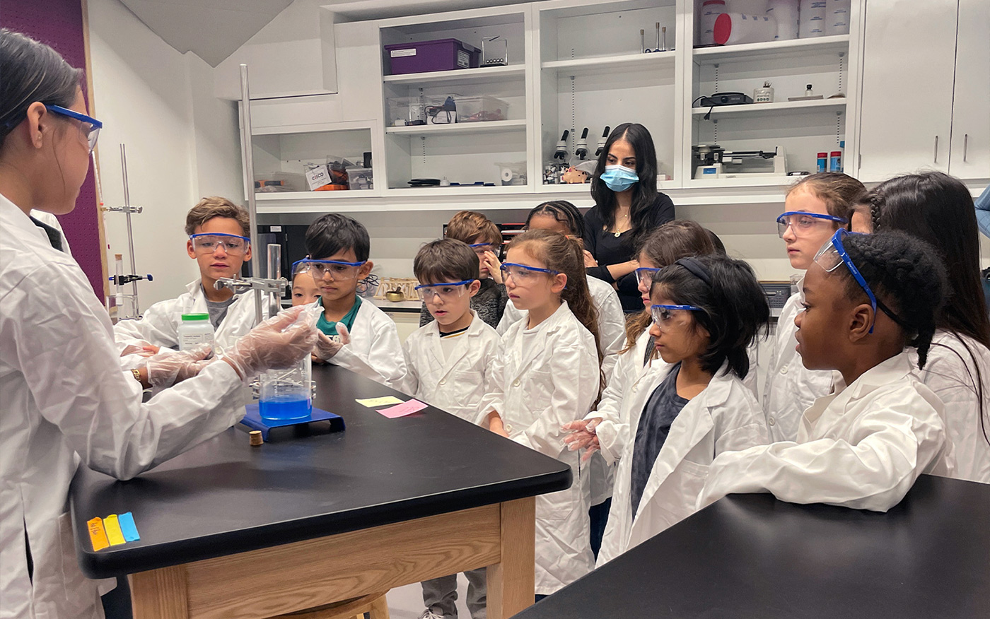 Middle school students demonstrating an experiment to the 2nd grade students at the Middle School Science lab