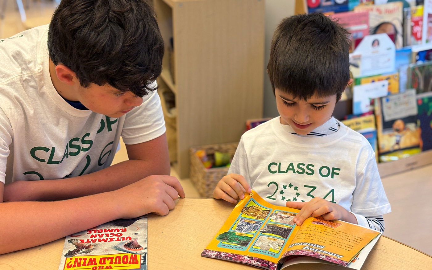 8th grader reads to Kindergarten buddy as part of the mentorship buddy program