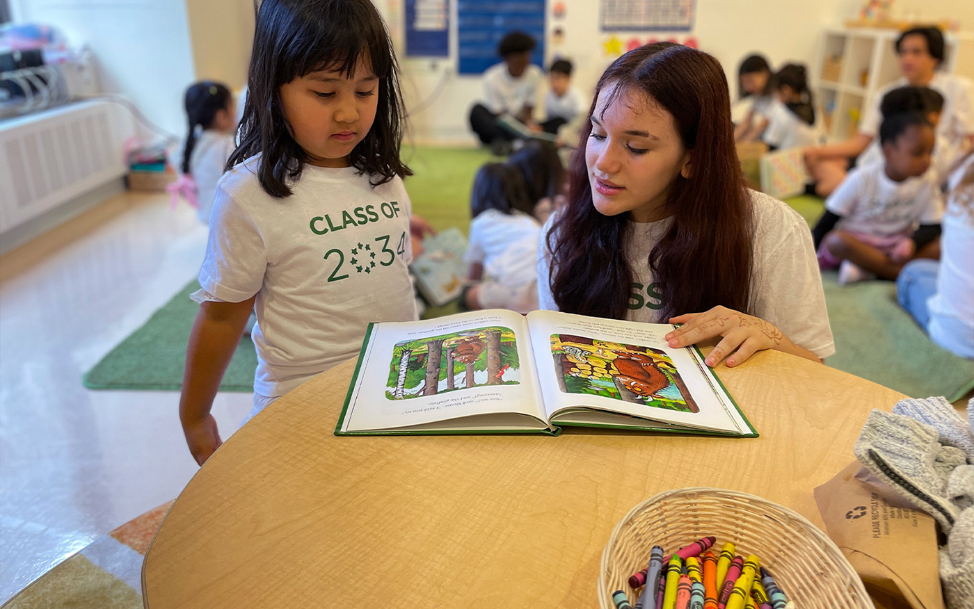 8th grader reads to Kindergarten buddy as part of the mentorship buddy program