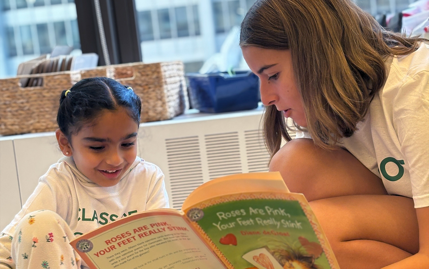 8th grader reads to Kindergarten buddy as part of the mentorship buddy program