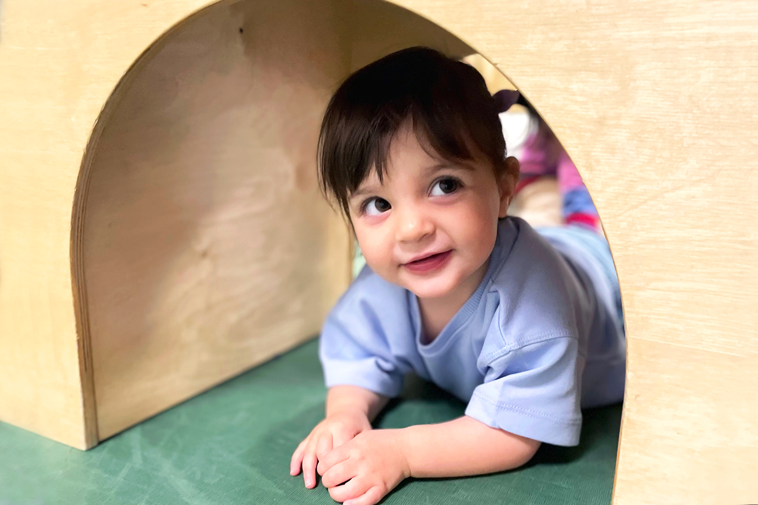 Pine Street School nursery student playing under wooden structure in the Movement Room