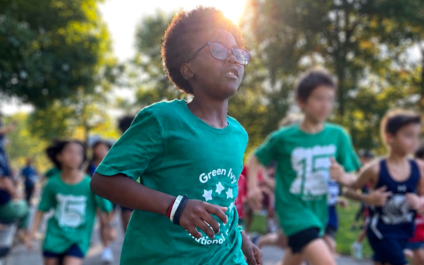 Cross country team member runs during a meet outdoors with other competitors in the background