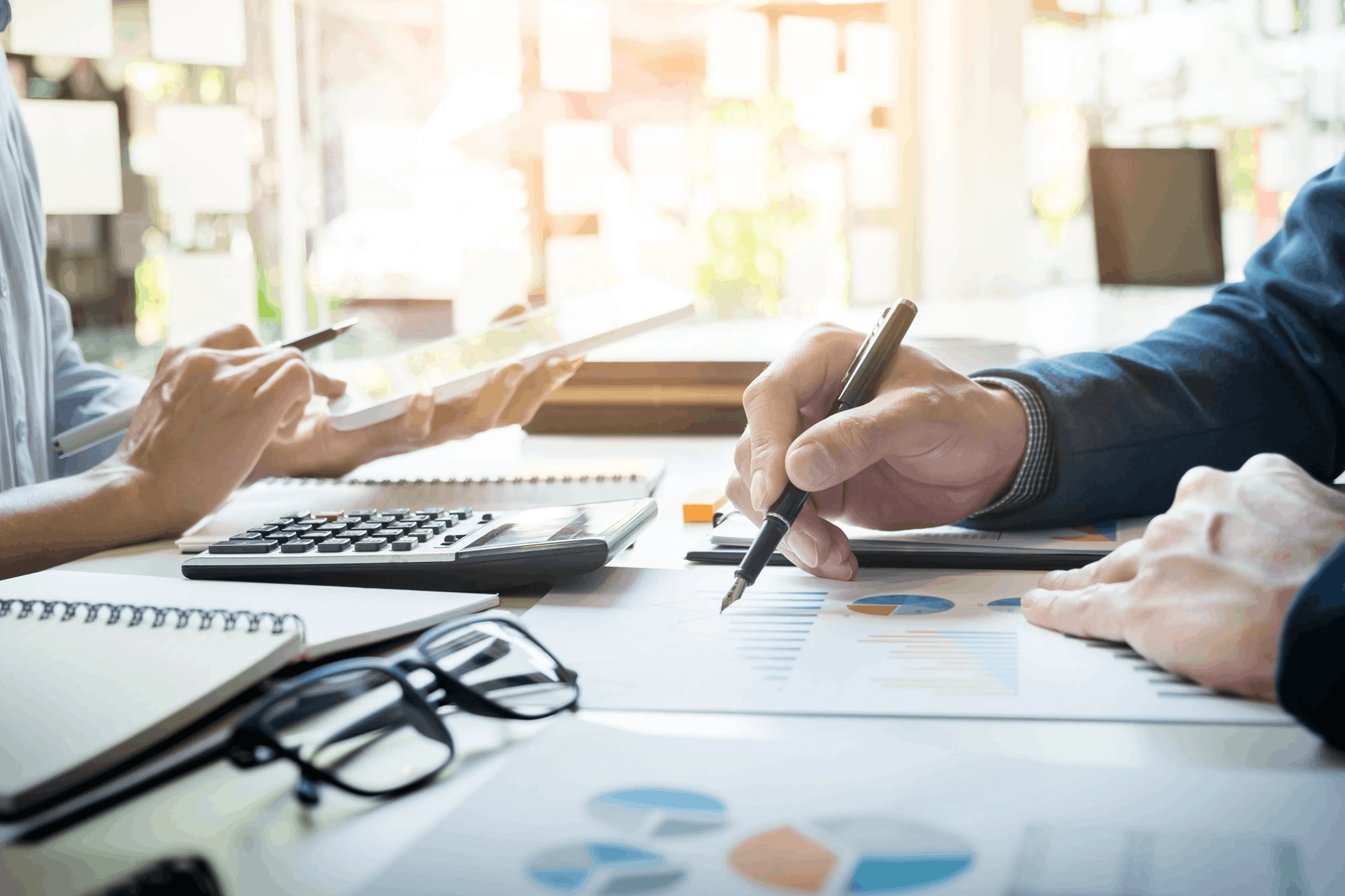 Business professionals reviewing reports and taking notes during a strategy meeting