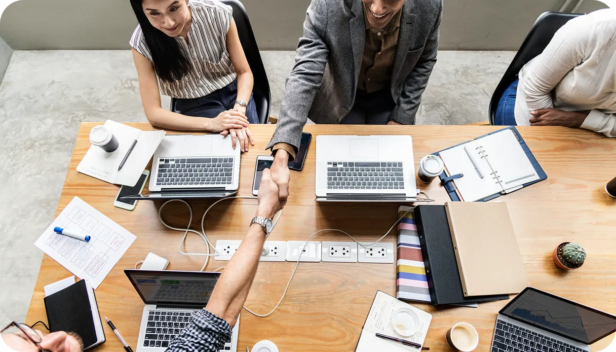 Business professionals shaking hands during a meeting to celebrate a new partnership