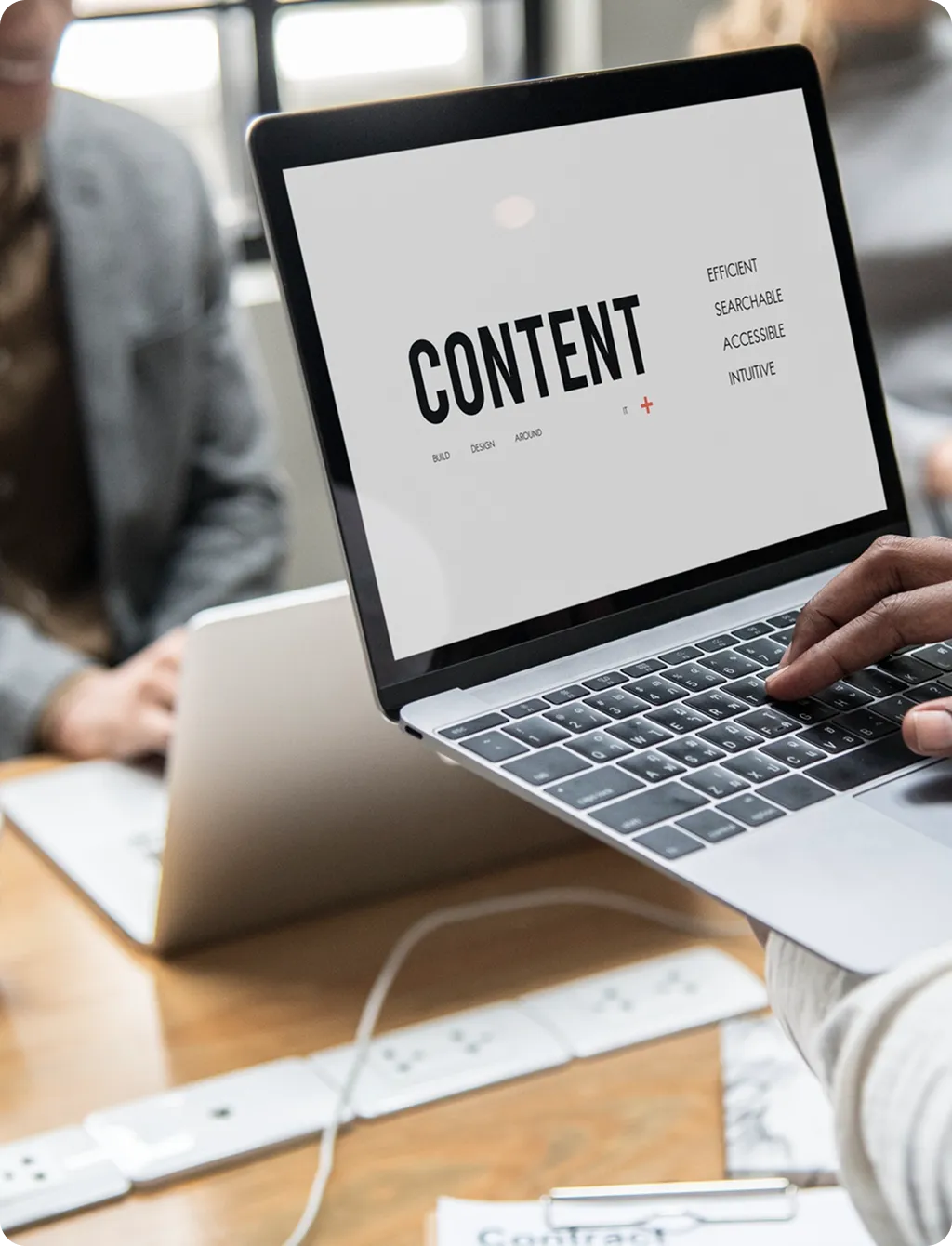 Laptop displaying a content strategy presentation during a team meeting