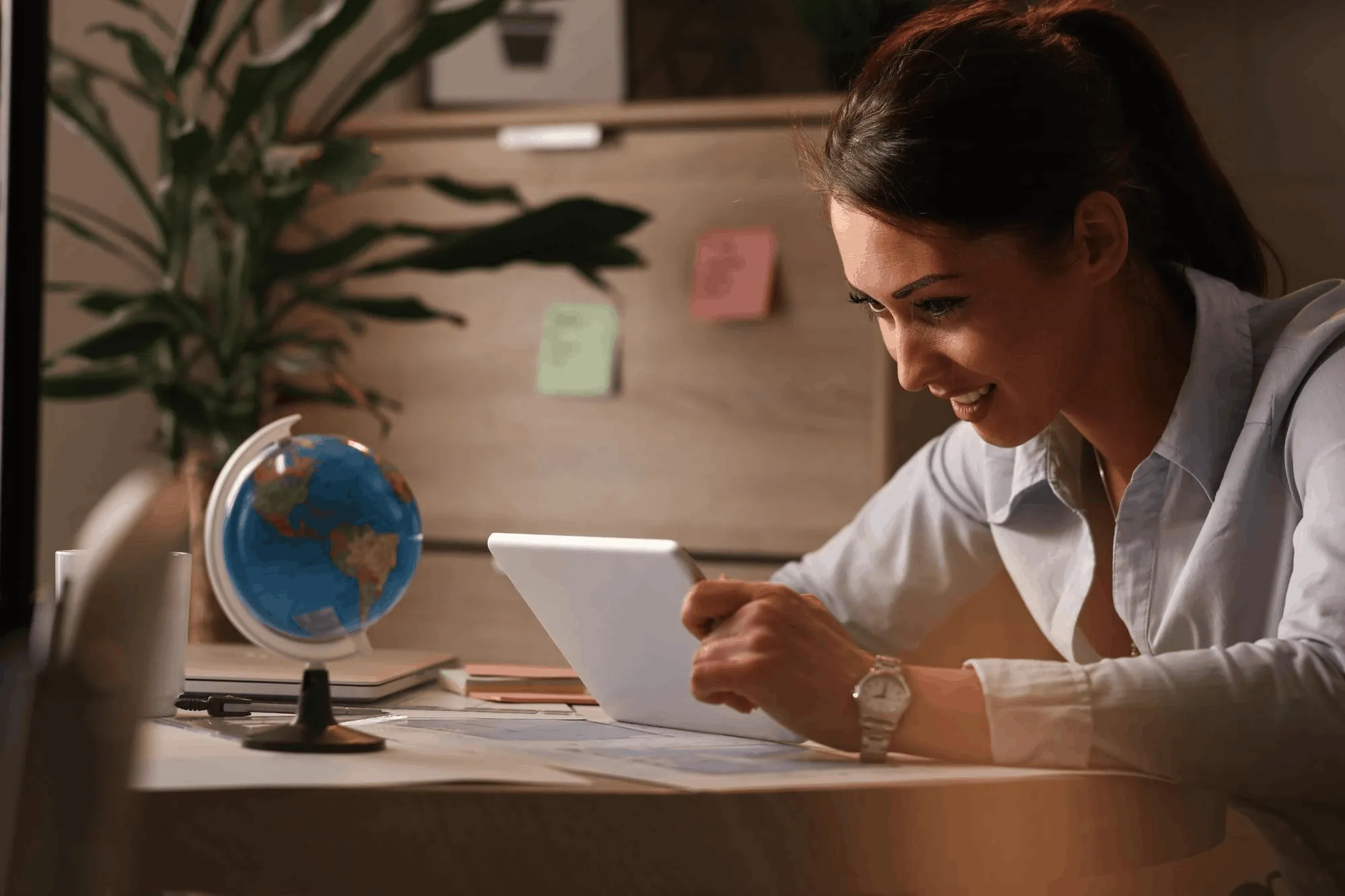 Professional reviewing research and notes on a tablet in a focused workspace