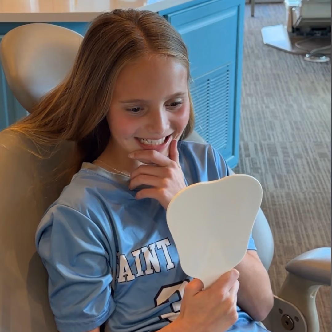 Child loving her new smile at Freeman Orthodontics