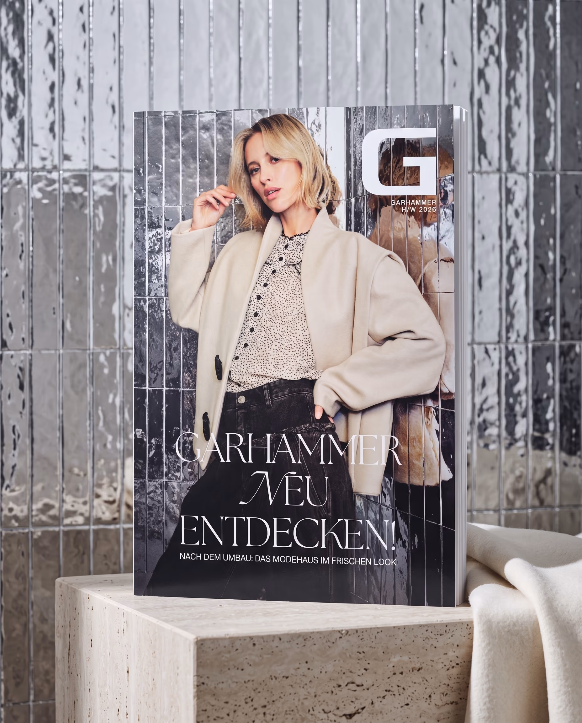 Cover-Mockup des GARHAMMER Magazins „NEU ENTDECKEN!“ Herbst/Winter 2026 vor verspiegelten Fliesen