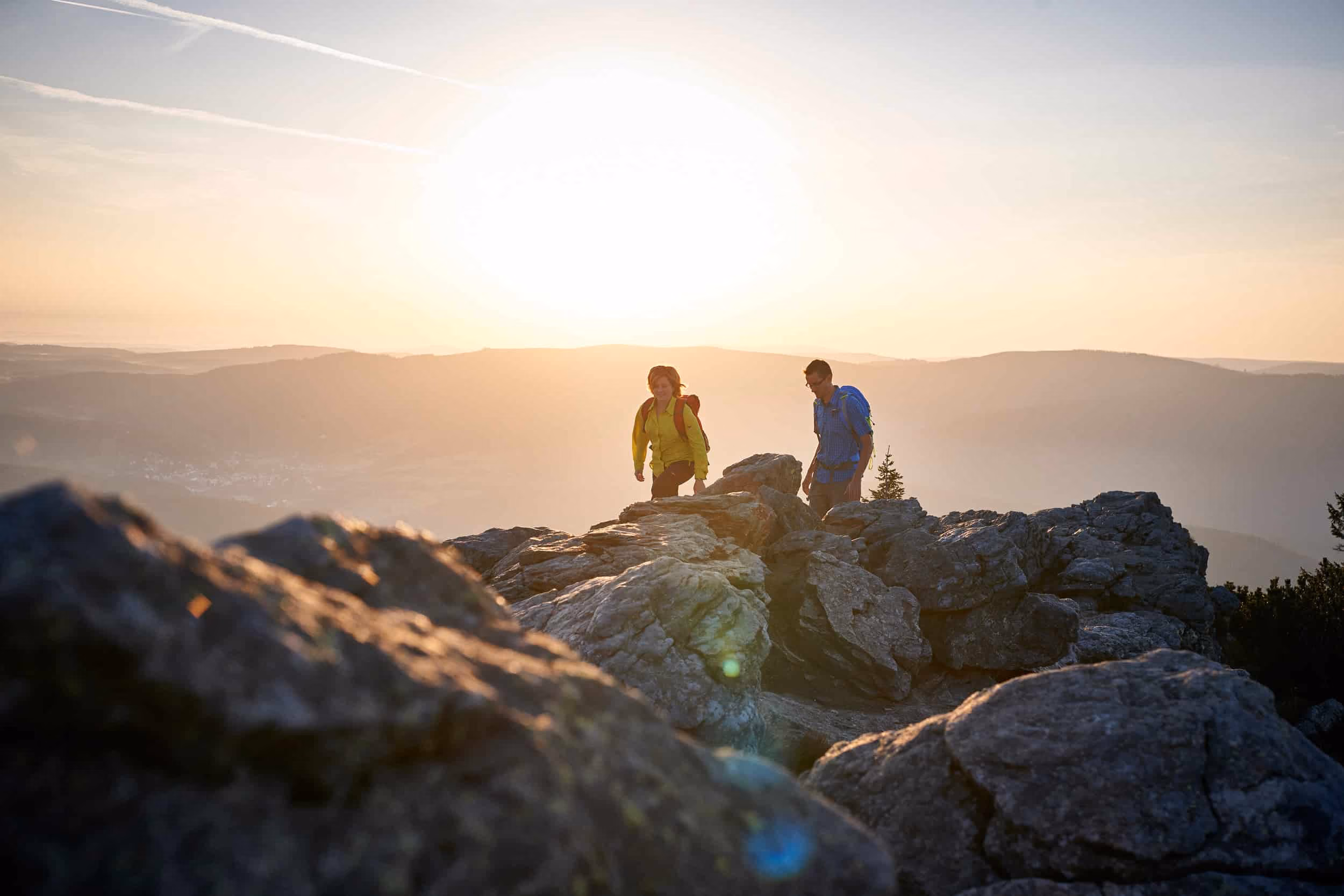 Wanderer auf den Gipfelfelsen des Großen Arber im Abendlicht