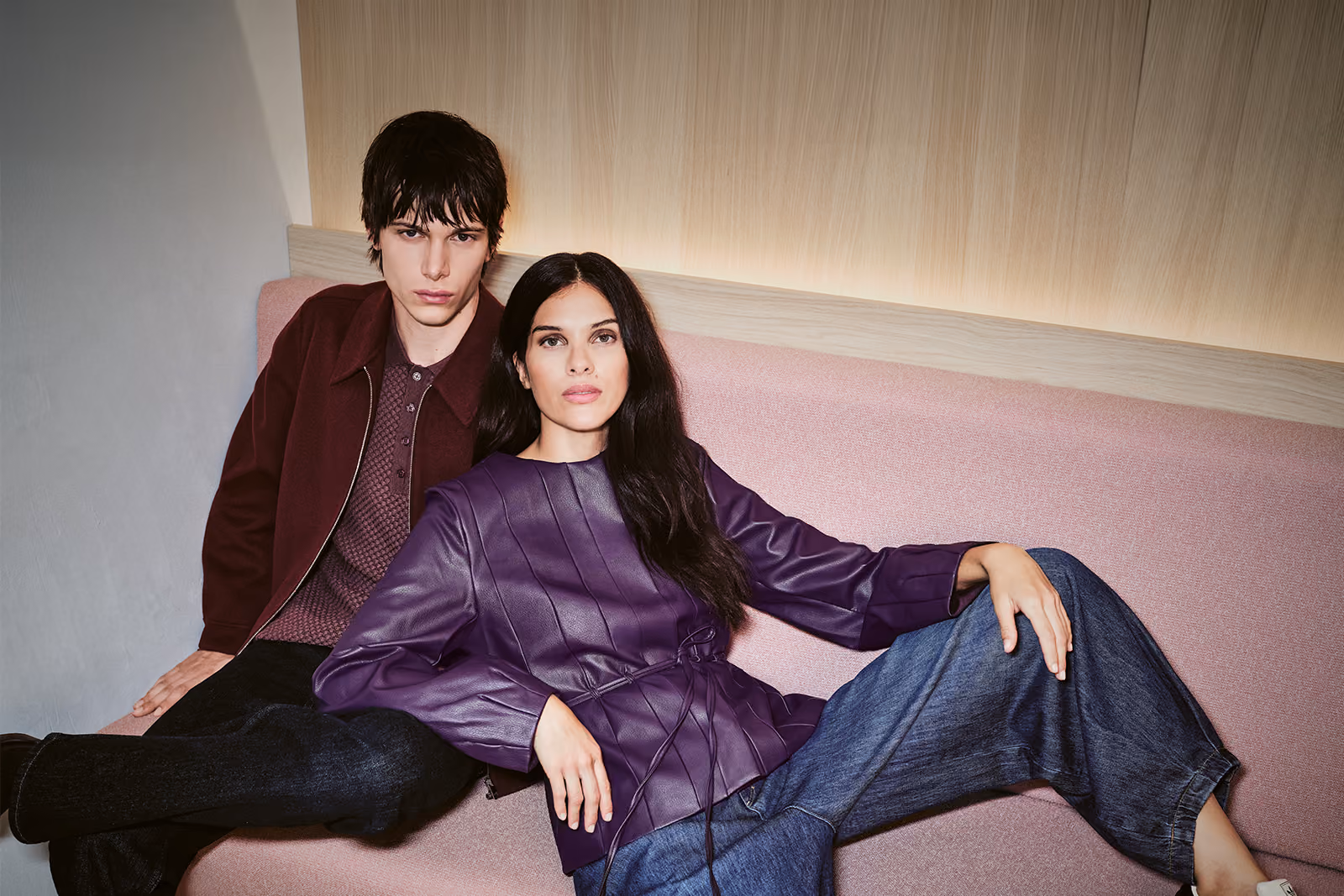 Zwei Models in Herbstmode auf einem rosa Sofa – Verkaufsoffener Sonntag bei GARHAMMER