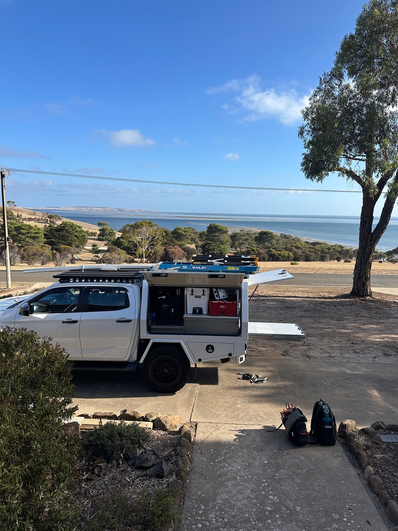 BBH Electrical ute loaded with ladders and tools, parked above the coast on a job away from Adelaide