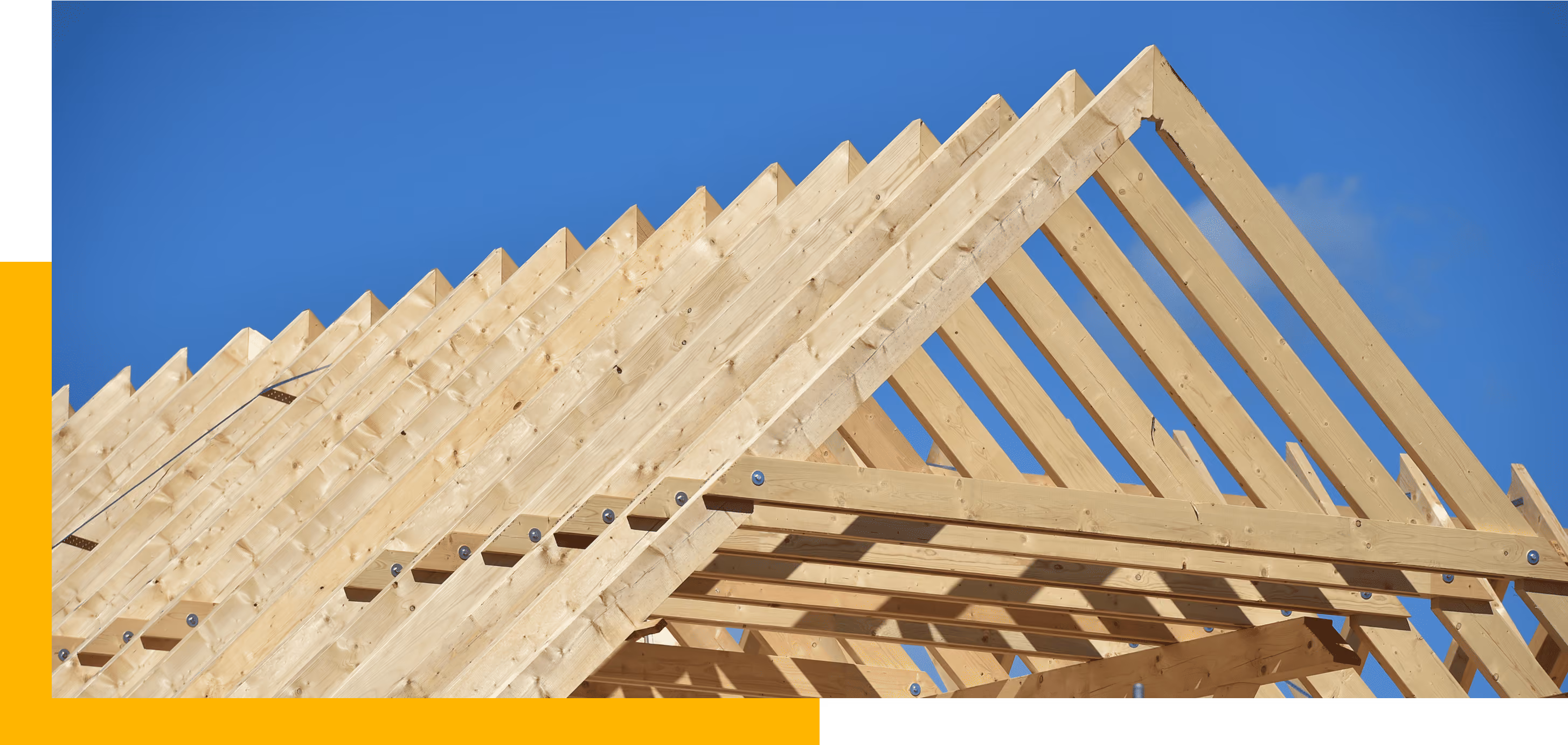 Holzrahmenstruktur für ein Dach vor klarem blauem Himmel bei sonnigem Wetter.