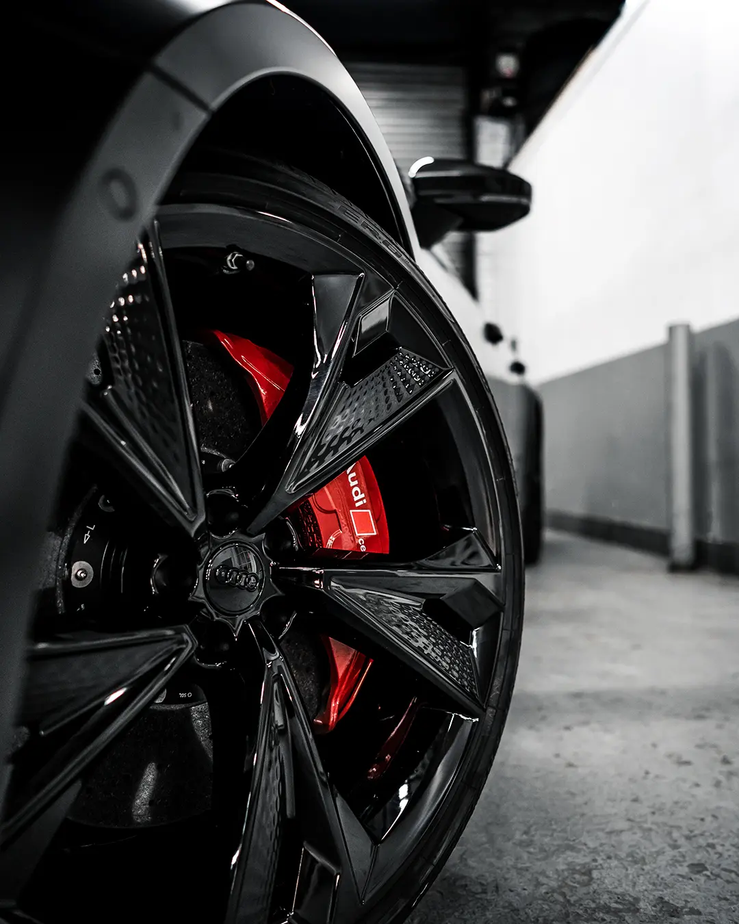 Gloss black powder coated wheel with a red painted brake caliper