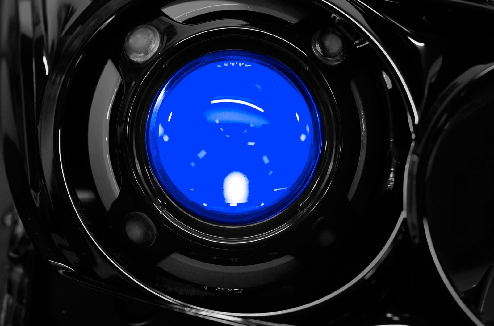 RGB demon eyes lit blue inside a headlight projector