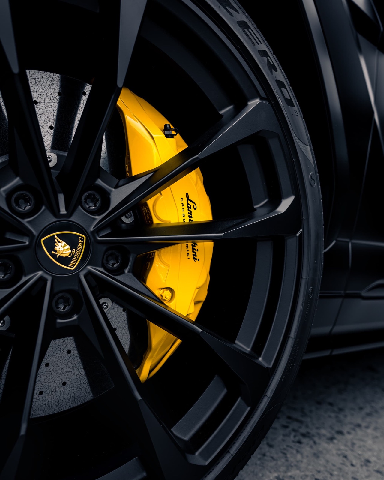 Lamborghini brake caliper painted yellow behind a black powder coated wheel