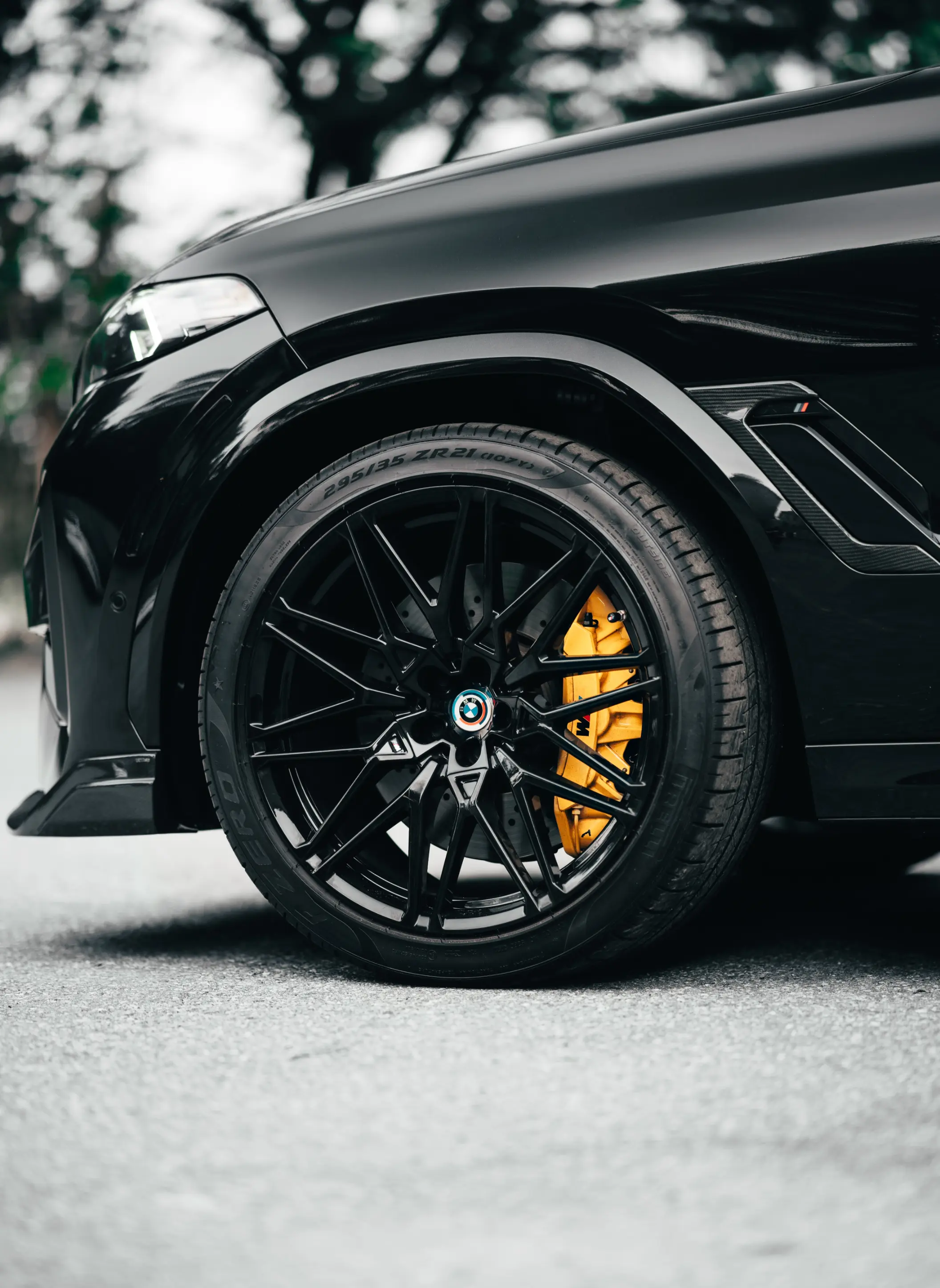 Black BMW X5 M with a yellow painted brake caliper behind a black wheel