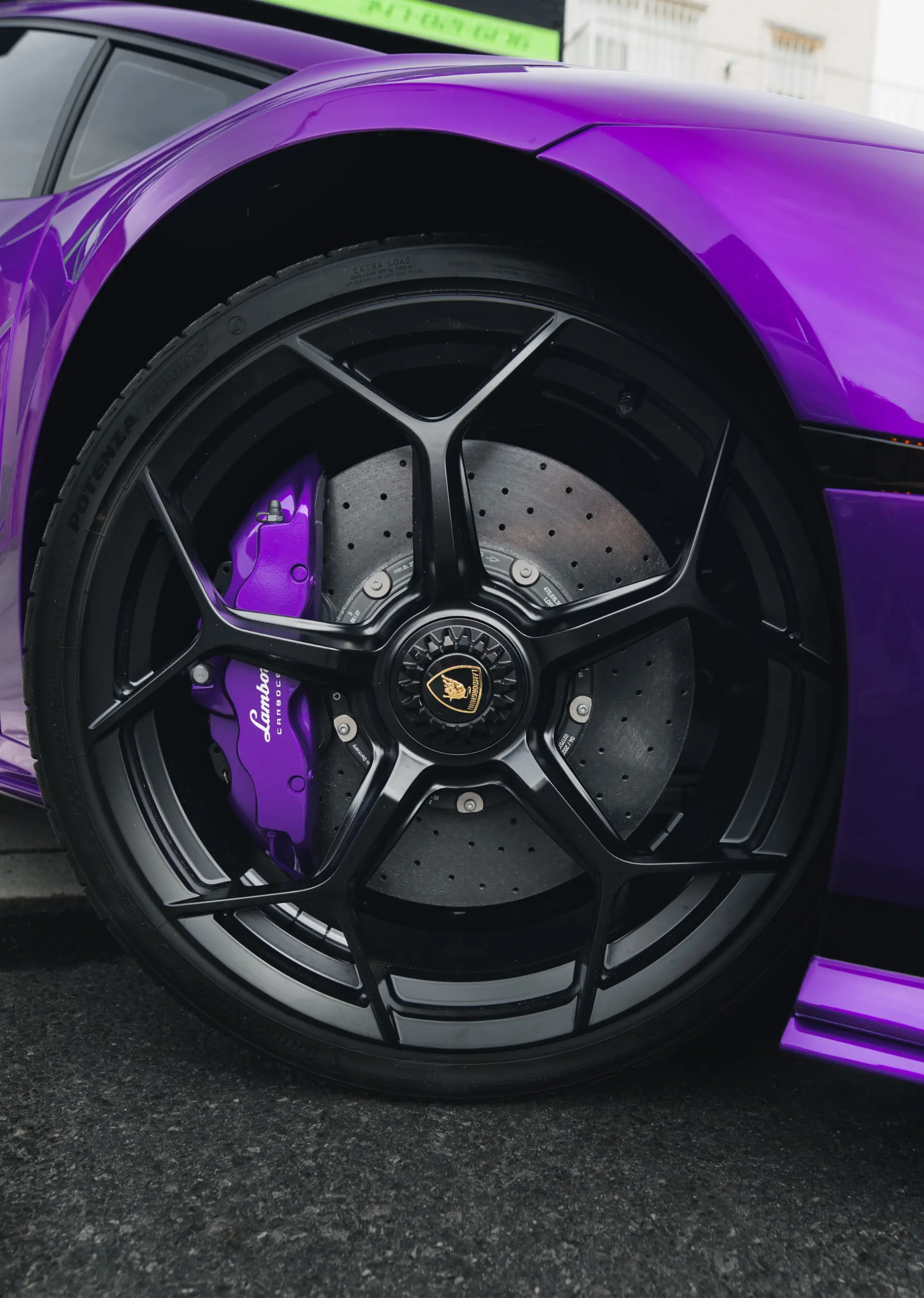 Purple painted brake caliper on a purple Lamborghini with black wheels