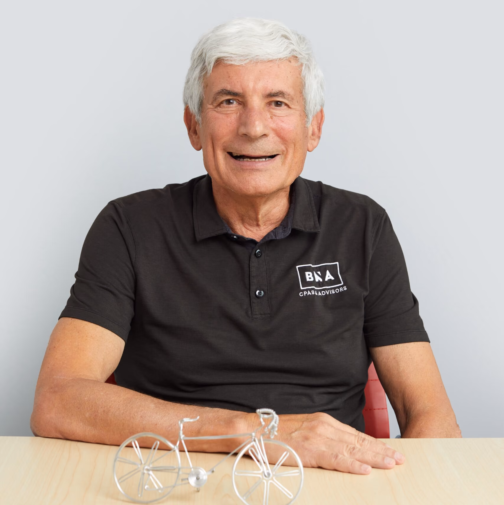 Headshot of Bernie Ackerman with a mini bicycle figure