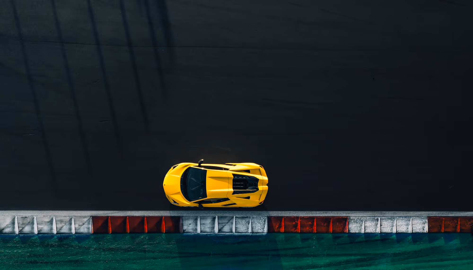 Top-down view of a yellow Lamborghini parked on a racetrack.
