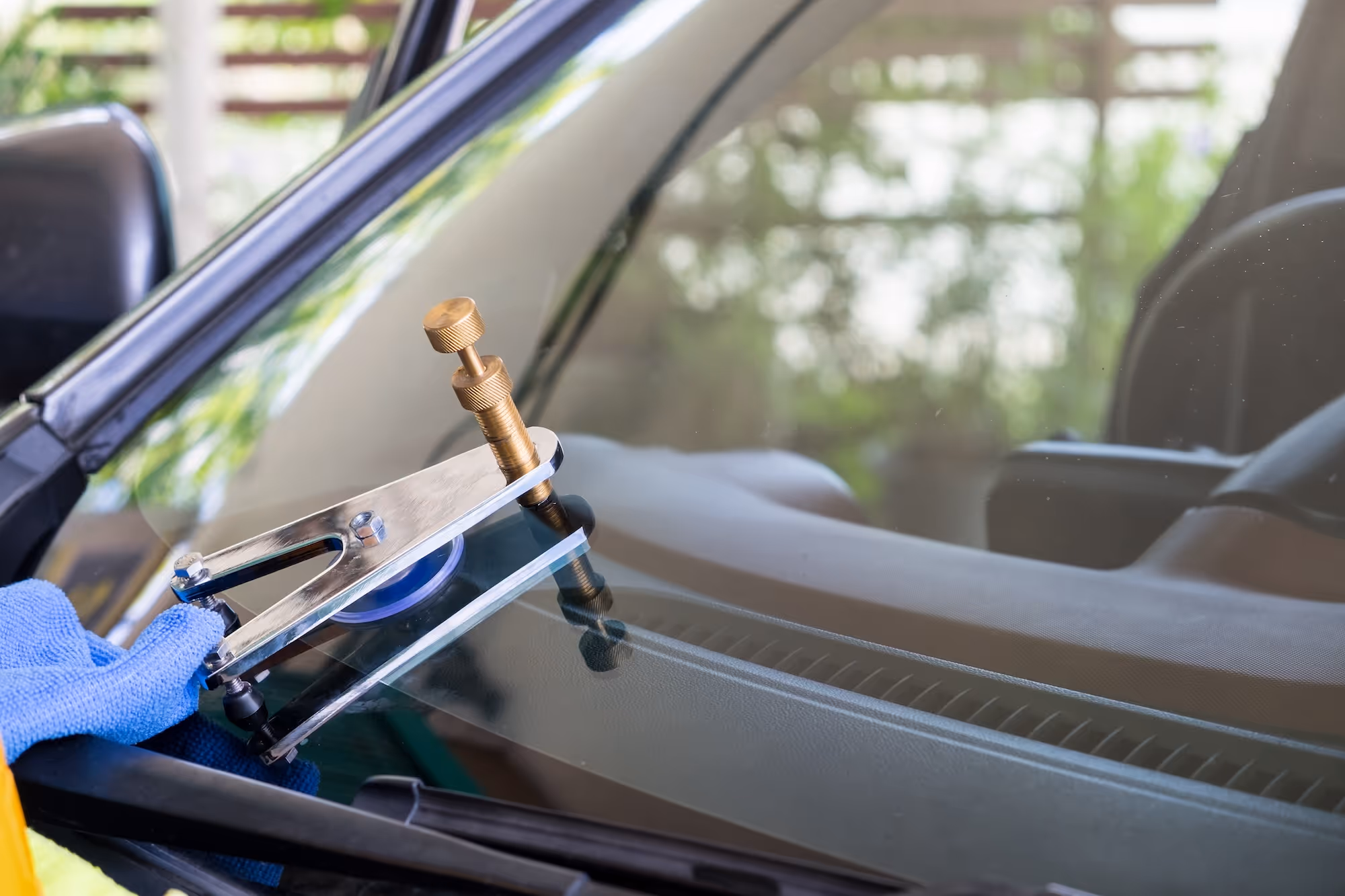 Windshield repair tool resting on the windshield of a car.