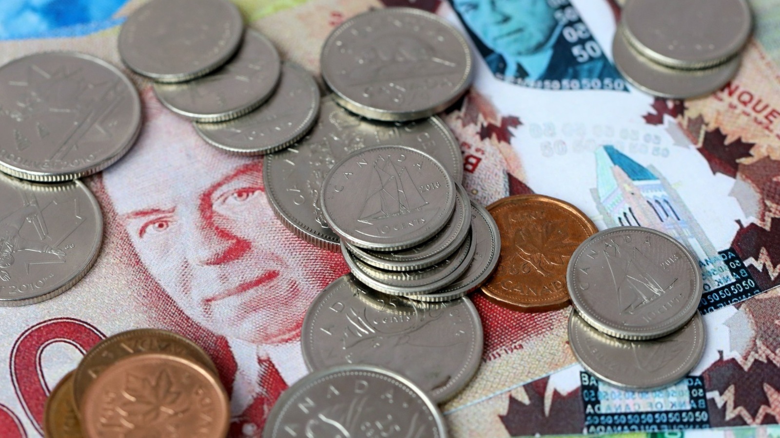 Canadian coins stacked on top of Canadian banknotes