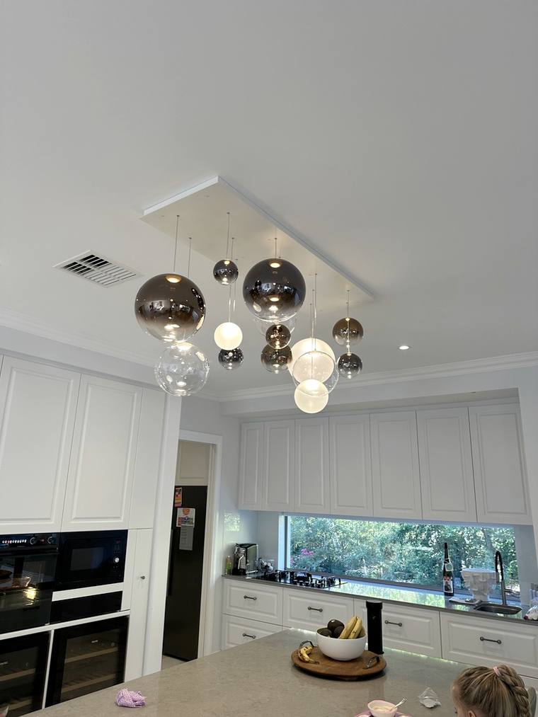 Copper pendant lighting installed over a kitchen bench.