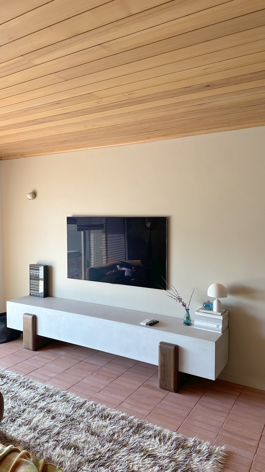 A wall-mounted TV installed flush with no visible cabling in a living room.