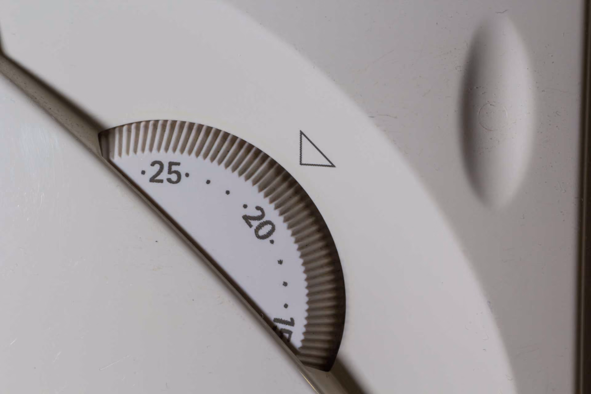 A protractor measuring tool showing degree markings from 25 to 20 degrees on white surface