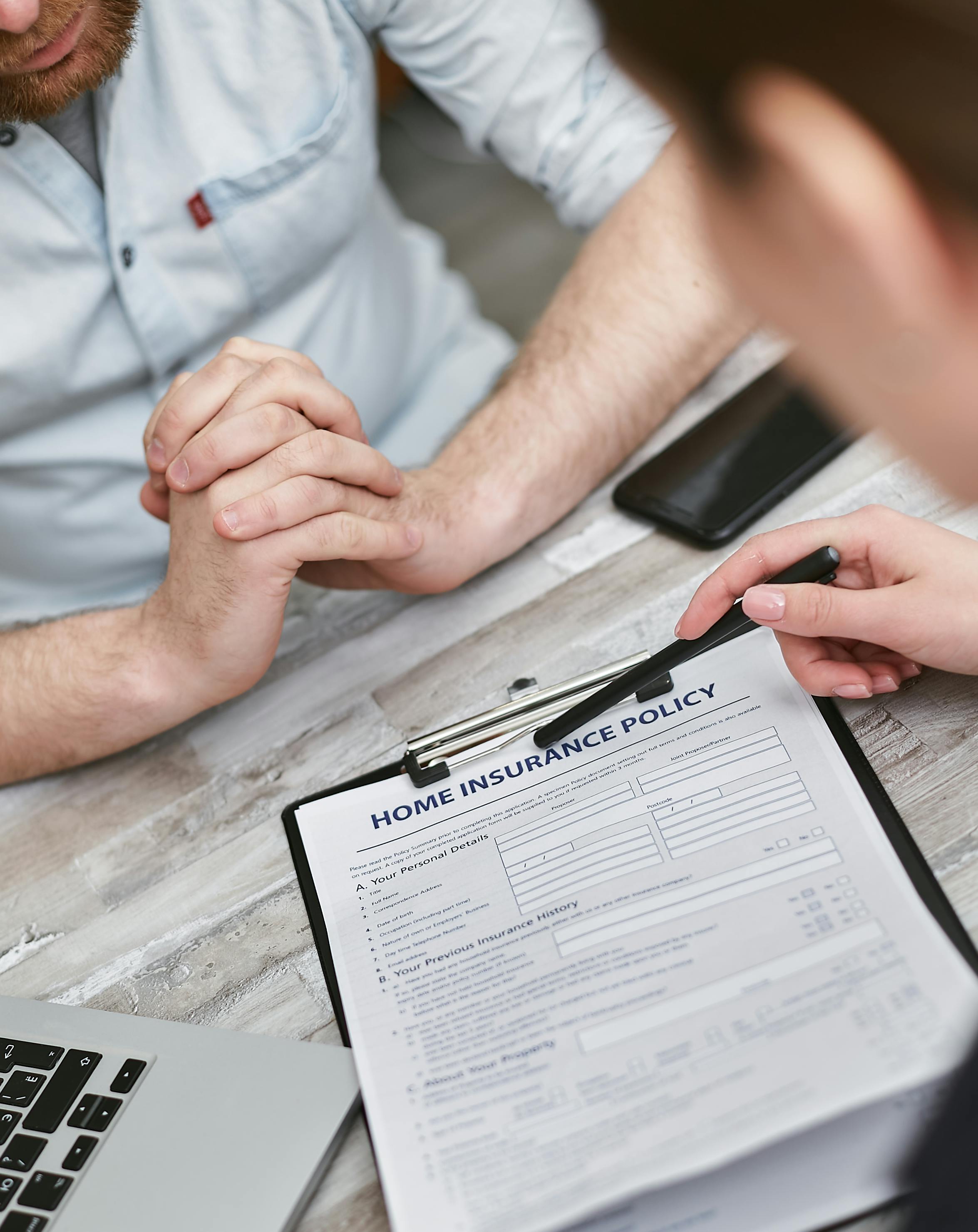 An insurance broker shows a client their home insurance polcy