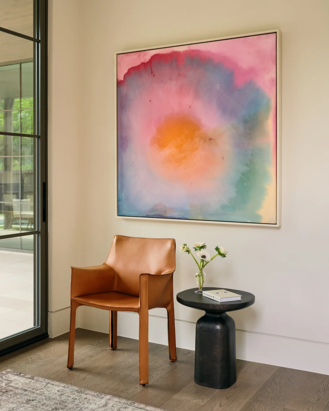 Dark brown tufted leather sofa below a textured white abstract painting on gray wall.