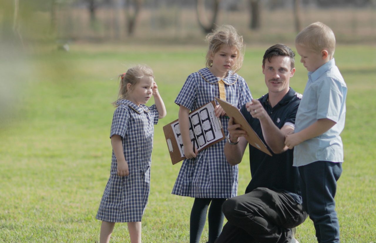 Teacher walking outdoors with primary school students