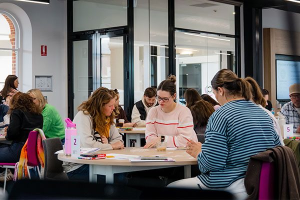 Educators seated in groups at tables during a leadership workshop