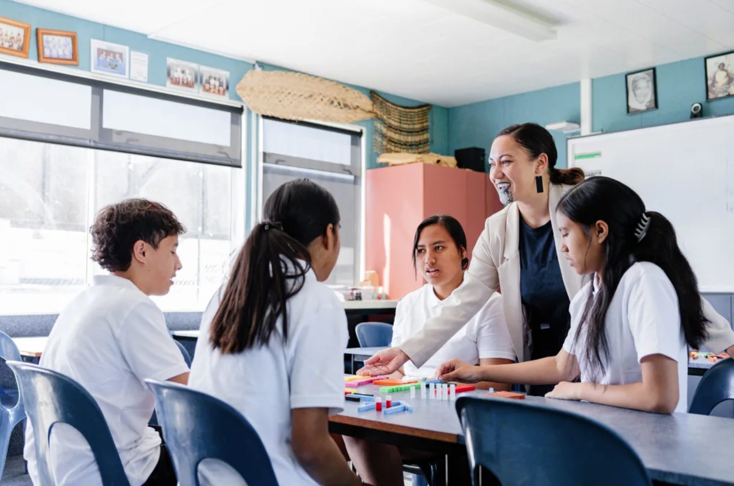 Teacher working with students at a classroom table
