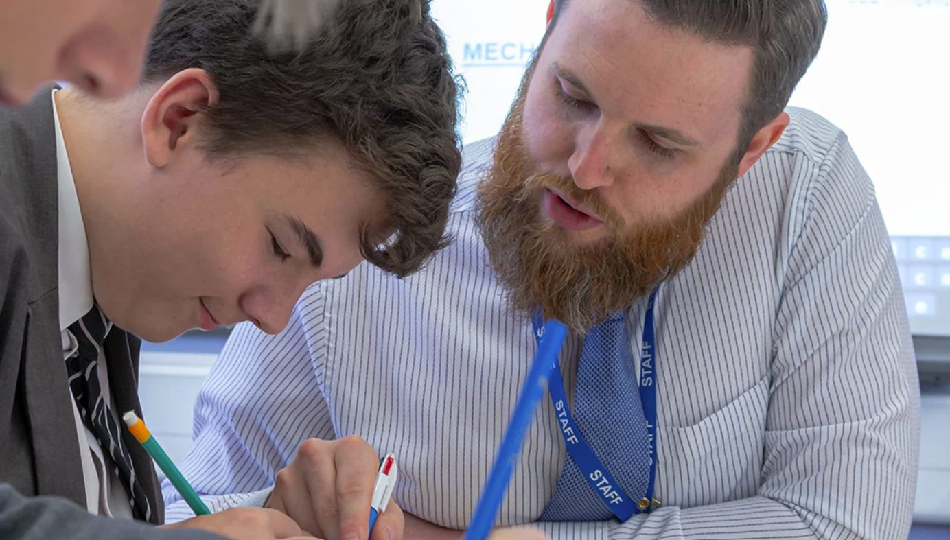 Two secondary students working side by side on written work