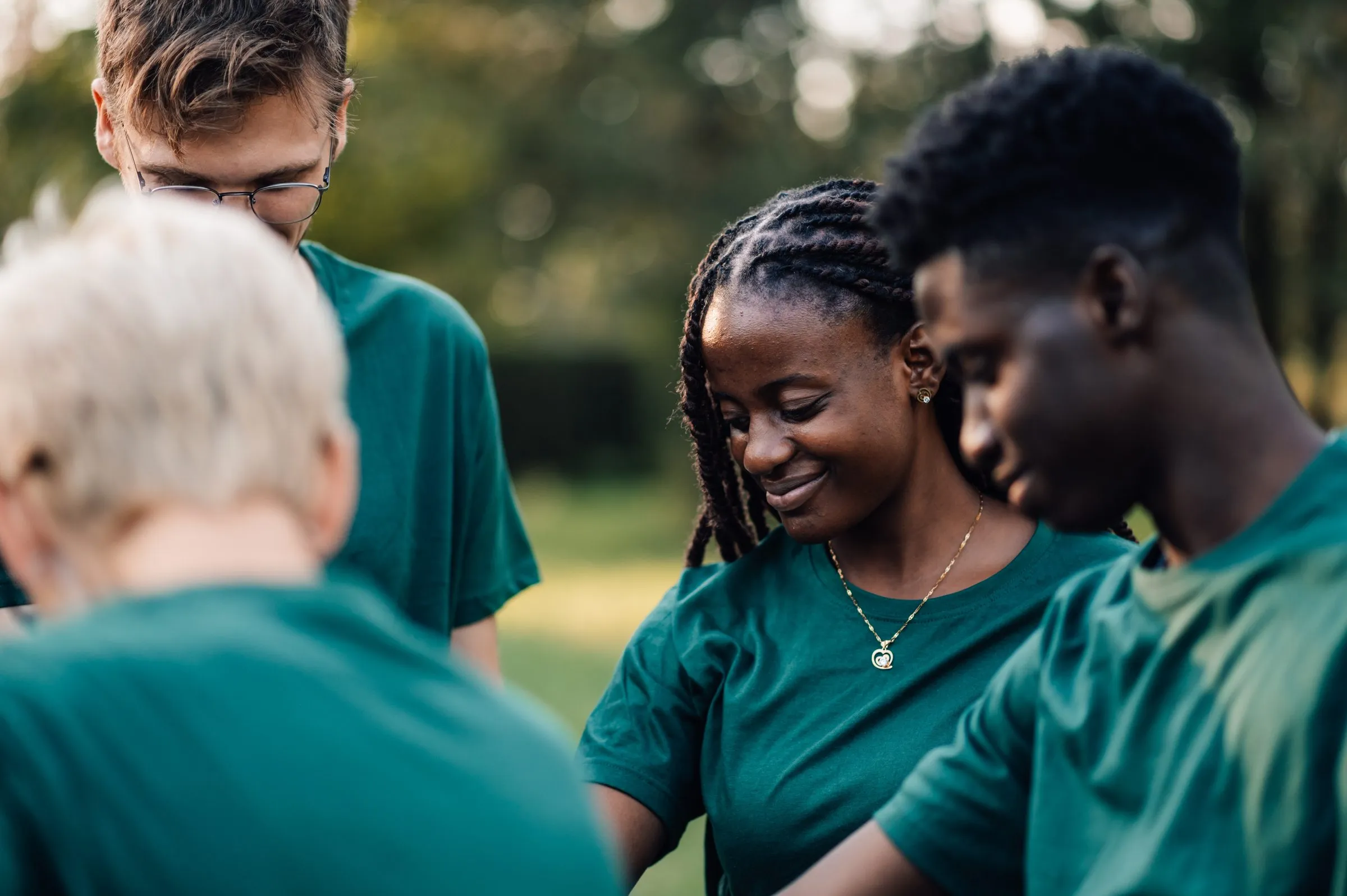 Volunteers in matching green shirts working together outdoors