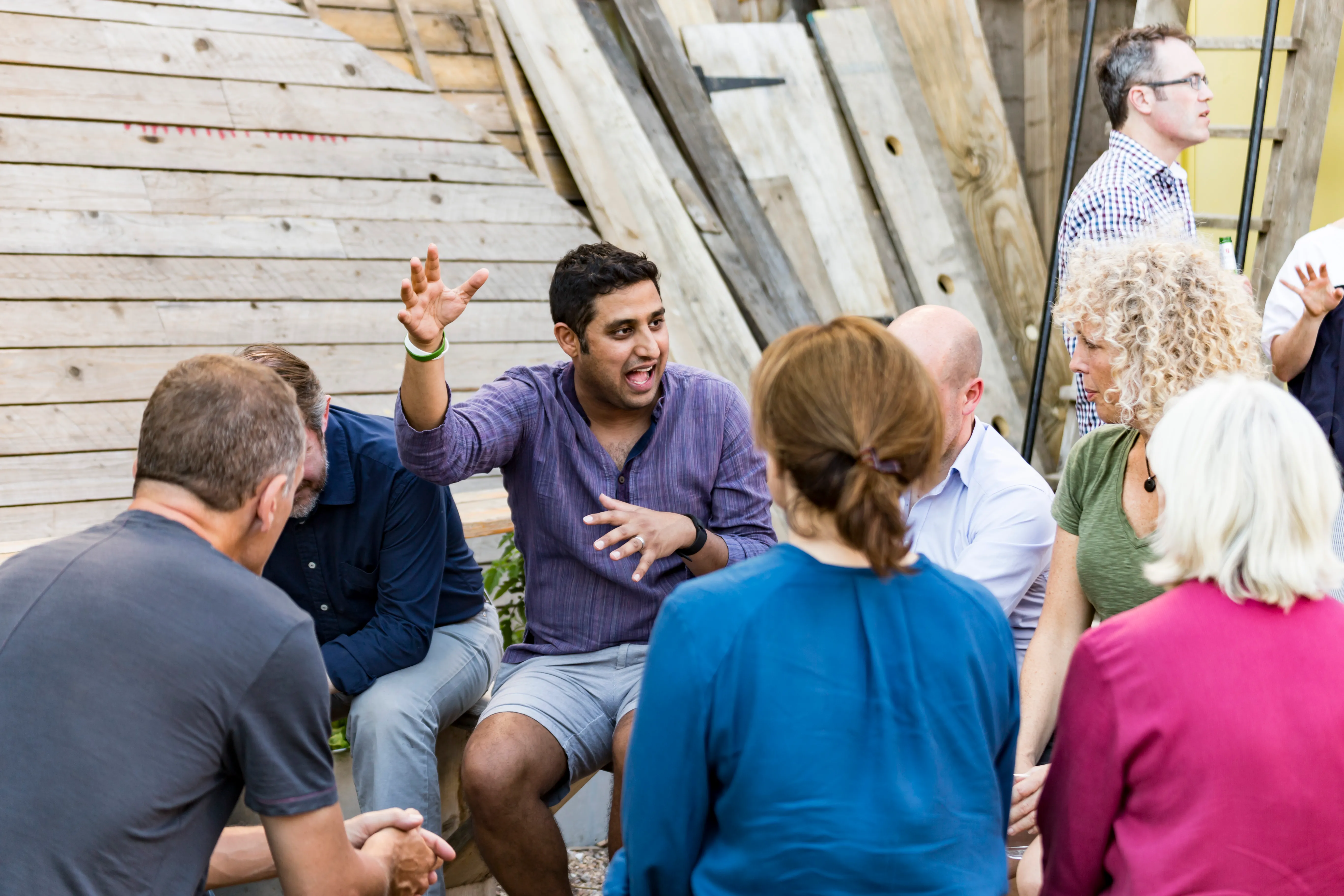 A group seated in a circle listening to one of the group members speaking
