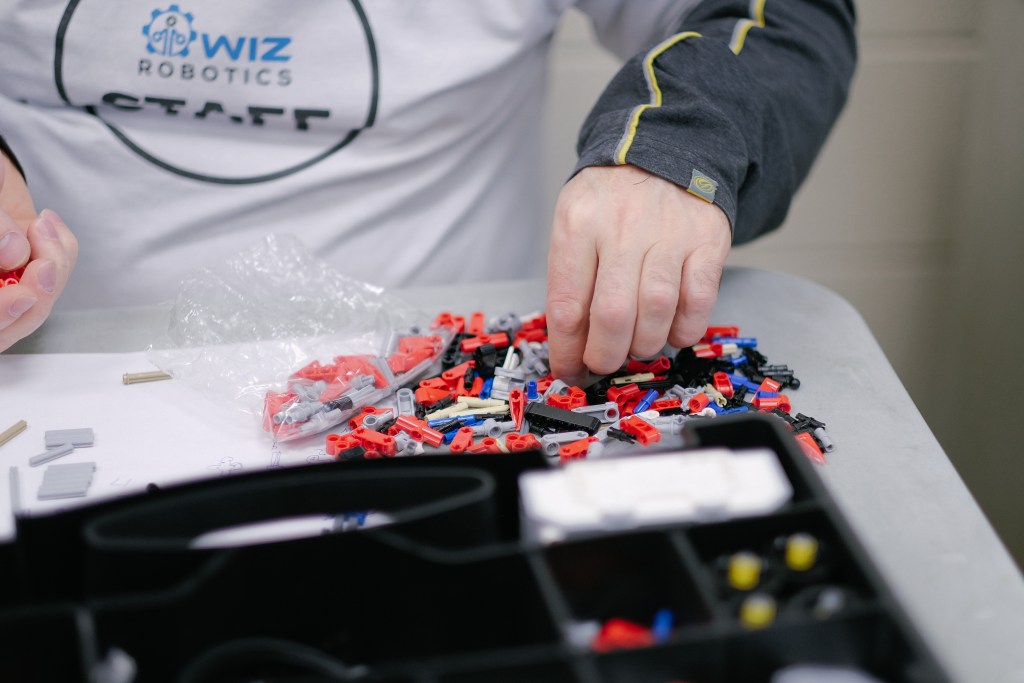 Wiz Robotics staff picking up robotics pieces