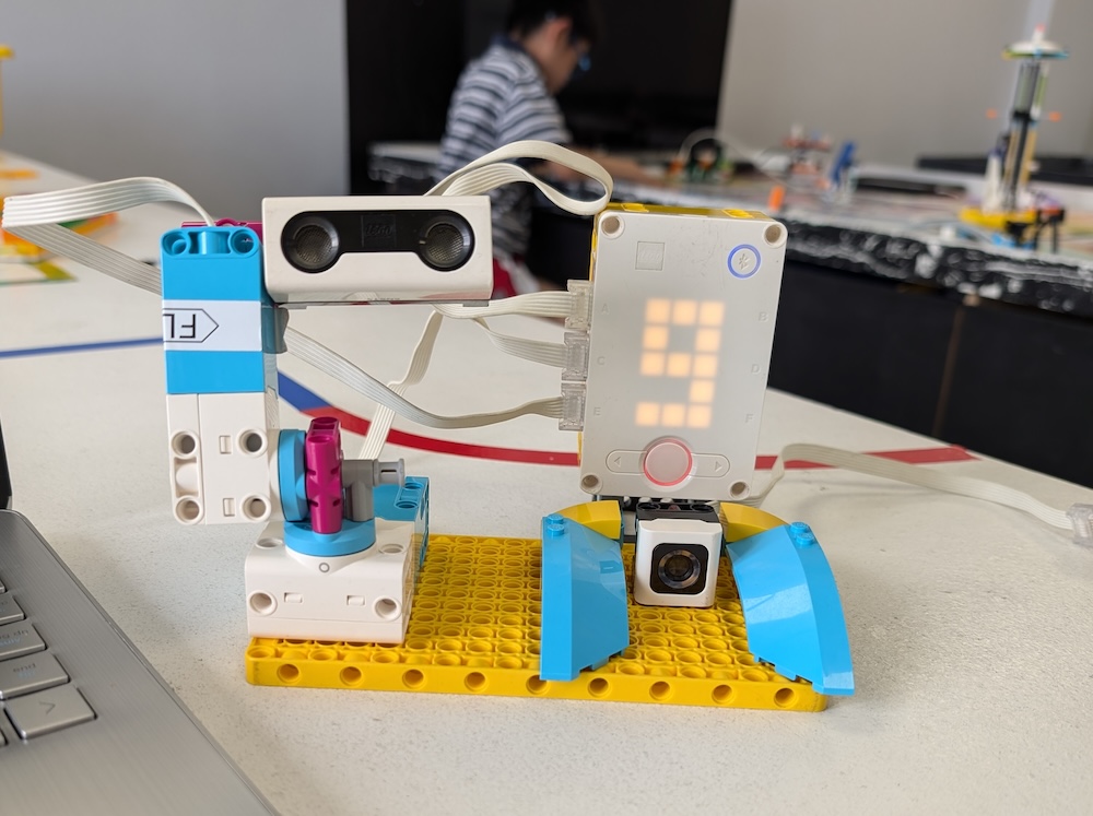 Middle school students programming motor sensors on a LEGO SPIKE Prime robot during STEM class.