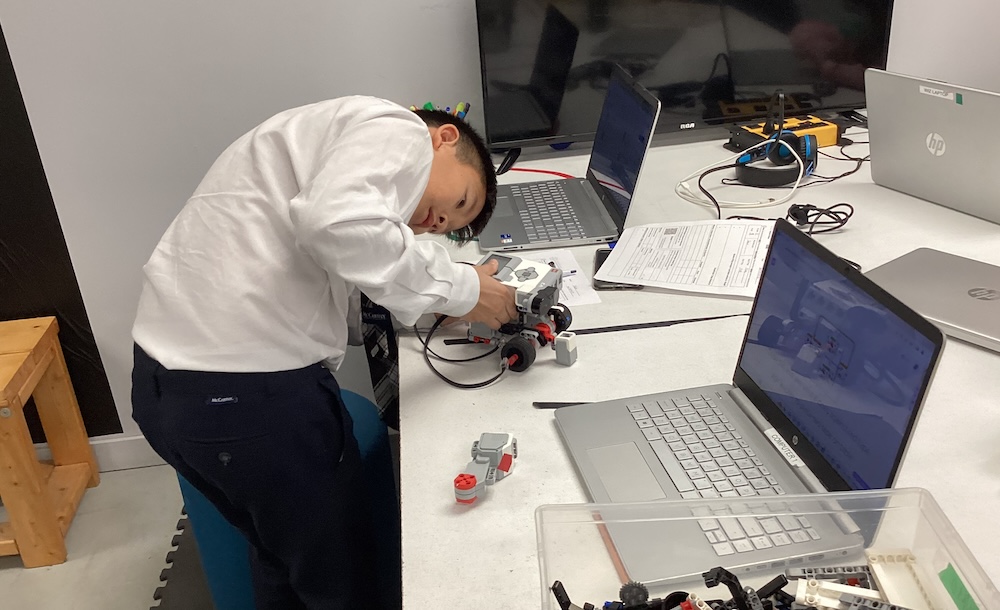 Students testing an autonomous LEGO Mindstorms EV3 robot equipped with infrared distance sensors.